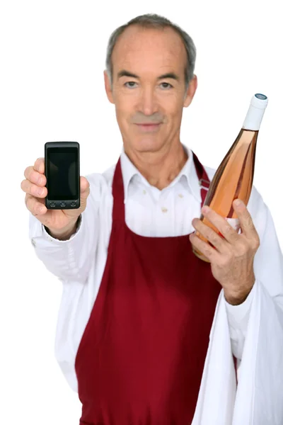 Man with a bottle of wine and a phone left blank for your message — Stock Photo, Image