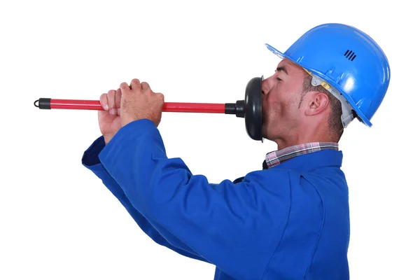 Plumber unplugging his mouth. Stock Image