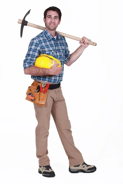 Laborer holding pickaxe Stock Photo
