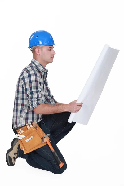Worker examining building plans Stock Photo
