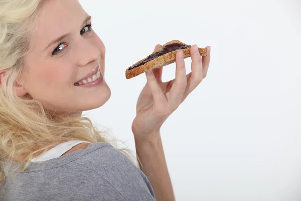 Nő eszik a kenyeret és a kenhető csokoládé — Stock Fotó