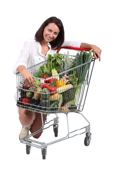 Mulher com carrinho cheio de legumes — Fotografia de Stock