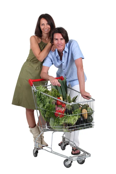 Couple debout avec chariot plein de légumes — Photo