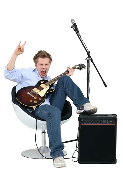 Молодой человек с гитарой играет рок-музыку — стоковое фото