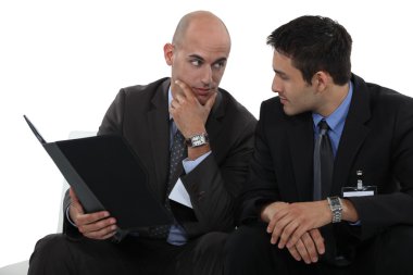Businessmen discussing a file clipart