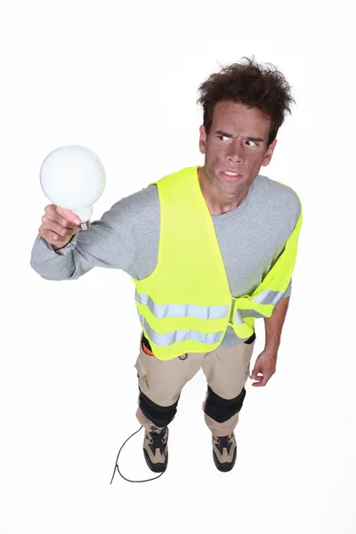 Electrocuted man holding a light bulb — Stock Photo, Image