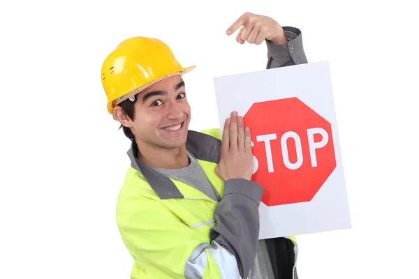 Trabajador de tráfico apuntando a señal de stop — Foto de Stock
