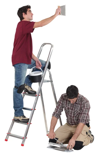 Tiler e aprendiz trabalhando juntos — Fotografia de Stock