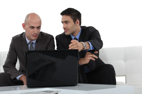 Empresários olhando para um laptop — Fotografia de Stock