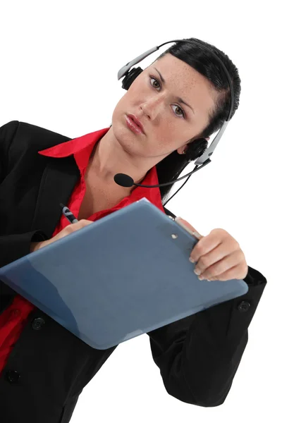 Kvinna i ett headset med ett urklipp — Stockfoto