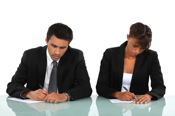 Two business writing at a desk — Stock Photo, Image