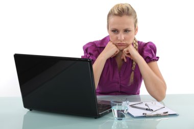 Frustrated woman staring at her laptop clipart