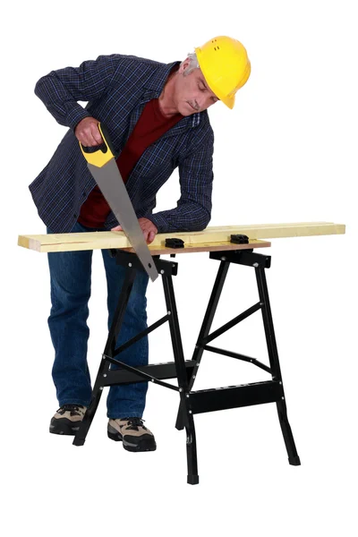 Tradesman segare una tavola di legno — Foto Stock