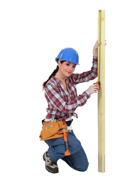 Woman measuring a piece of wood — Stock Photo, Image