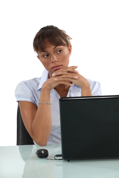 Pensive businesswoman sat at desk Royalty Free Stock Images