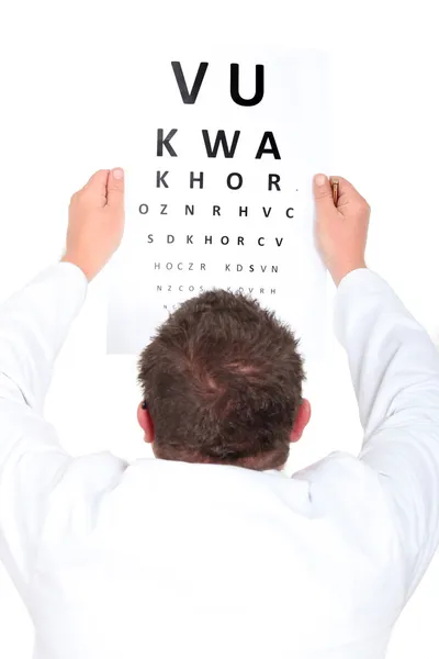 Optician holding up an eyechart — Stock Photo, Image