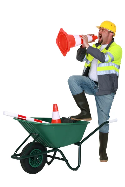 Laborer shouting into traffic cone — Stock Photo, Image