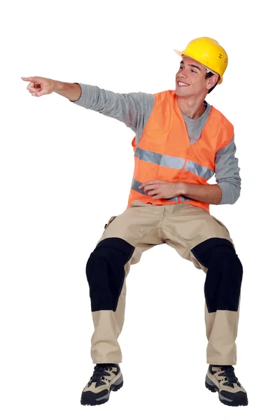 Un trabajador de la construcción apuntando a una dirección . — Foto de Stock