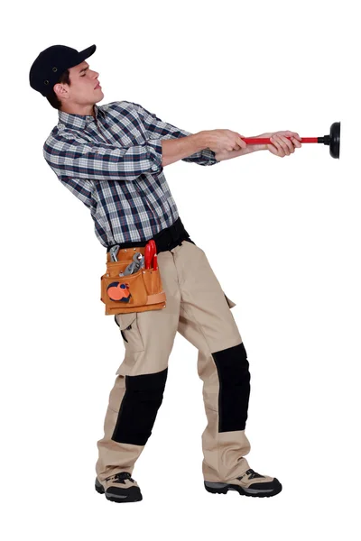 Handyman pulling a plunger — Stock Photo, Image