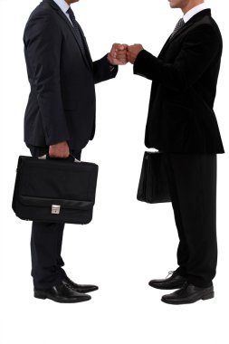 Two businessmen bumping fists clipart