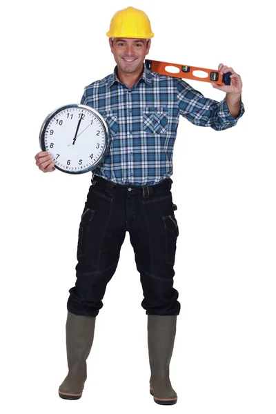 Ремесленник держит часы и уровень — стоковое фото