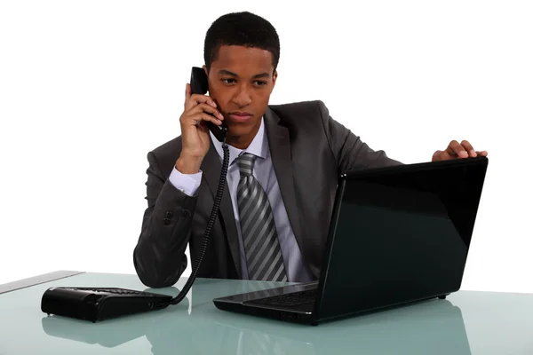 Uitvoerend met een telefoon en een laptop — Stockfoto