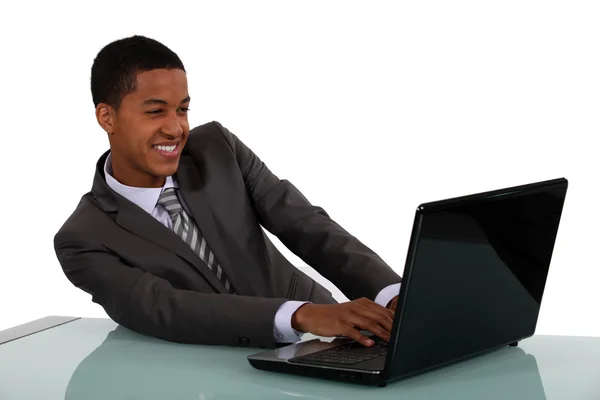 Черный бизнесмен сидел с ноутбуком — стоковое фото