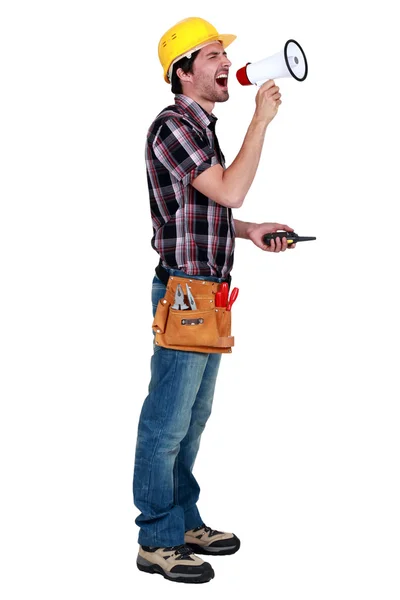 Craftsman holding a walkie talkie and shouting through a megaphone — Stock Photo, Image