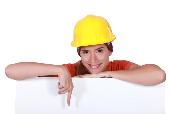 指向空白海报的女性建筑工人 — 图库照片