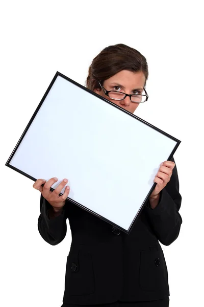 Young secretary with glasses lowered holding white board — Stock Photo, Image