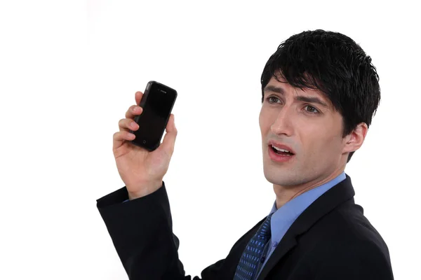 Businessman holding mobile phone looks worried — Stock Photo, Image