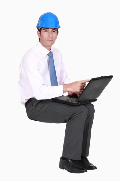 Μηχανικός που κάθεται στο κενό copyspace με ένα φορητό υπολογιστή — Φωτογραφία Αρχείου