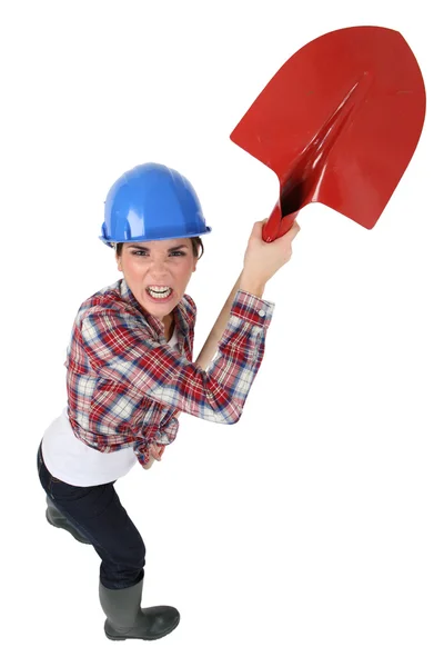 Angry craftswoman holding a shovel — Stock Photo, Image