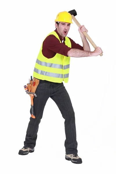 Construction worker smashing with a sledgehammer Royalty Free Stock Photos