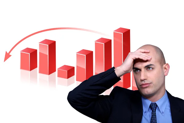 Stressed businessman standing by bar chart — Stock Photo, Image