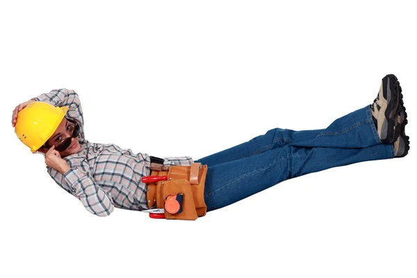Female builder in sunglasses laying down — Stock Photo, Image
