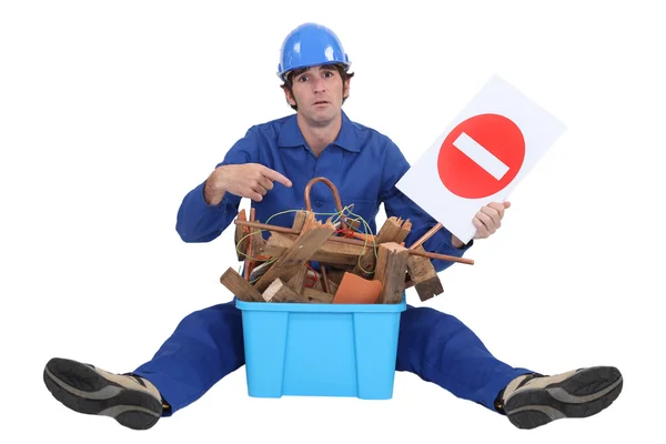 Arbeiter mit einem Karton mit alten Materialien und einem Verbotsschild — Stockfoto