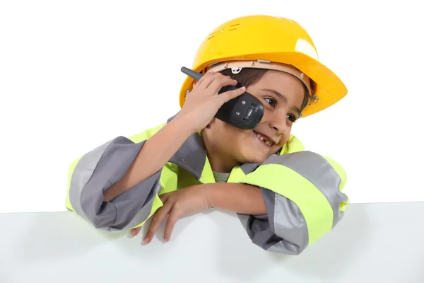 Un niño vestido de hombre de carretera con un teléfono celular —  Fotos de Stock