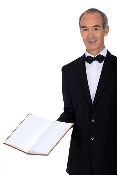 Middle-aged waiter holding menu — Stock Photo, Image