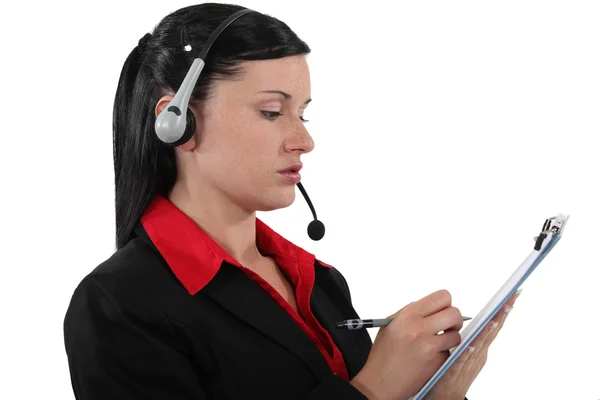 Brunette call center werknemer met clip-boord en pen — Stockfoto