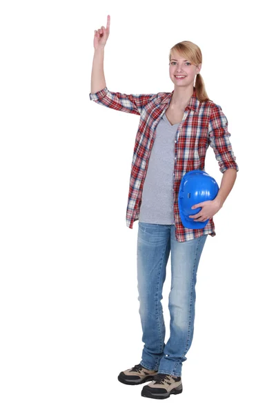 Female carpenter pointing upwards — Stockfoto