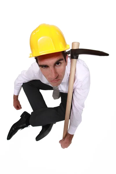 Grumpy businessman with a pickaxe — Stock Photo, Image