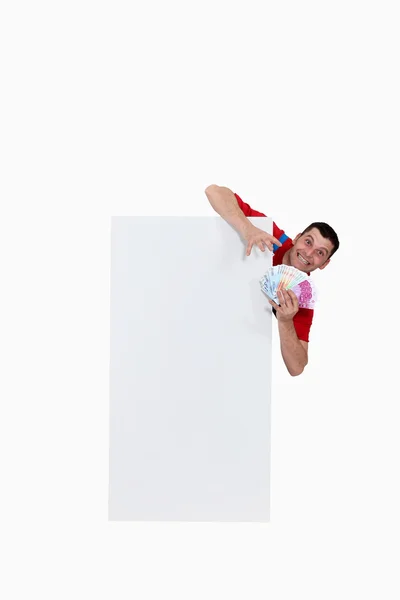 Man behind white panel with cash — Stock Photo, Image