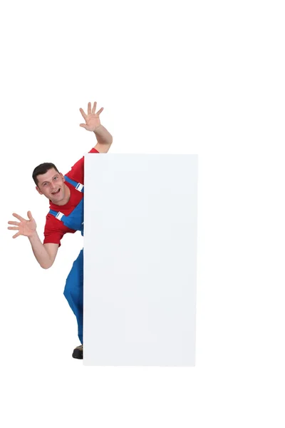 Scary builder jumping out from behind poster — Stock Photo, Image