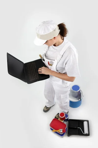 Craftswoman schilder met een laptop — Stockfoto