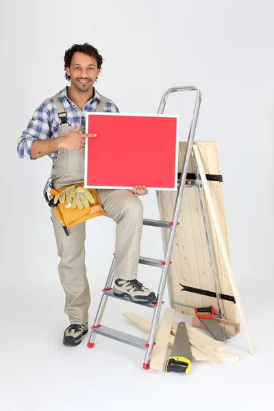 Männlicher Bauarbeiter hält Tafel in der Hand — Stockfoto