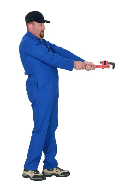 Plumber with wrench pretending to loosen bolt — Stock Photo, Image