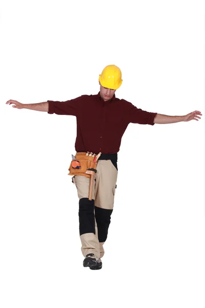 Builder balancing on one leg — Stock Photo, Image