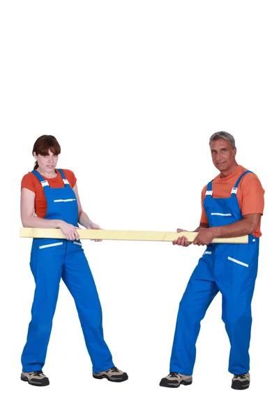 Construction workers pulling a piece of timber — Stock Photo, Image