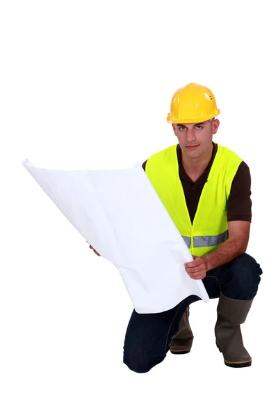 Tradesman studying a blueprint — Stock Photo, Image